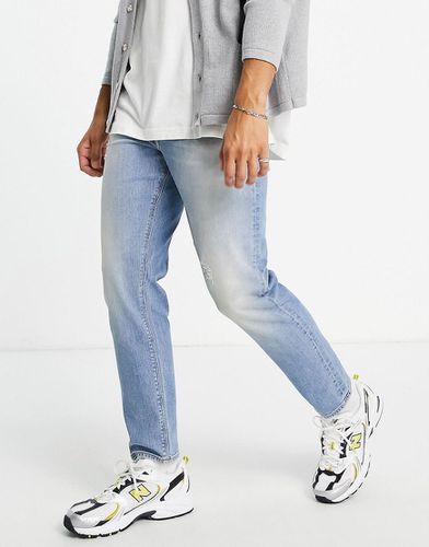 Jeans affusolati lavaggio chiaro con abrasioni-Blu - ASOS DESIGN - Modalova